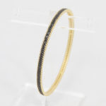 gold & black bangle frieda freida rothman,
